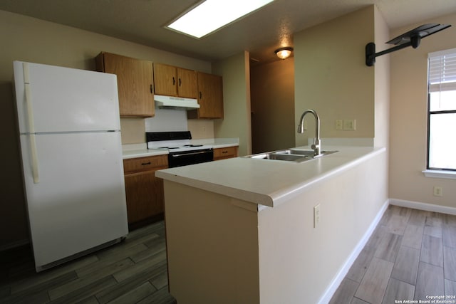 kitchen featuring kitchen peninsula, dark hardwood / wood-style flooring, white appliances, and sink