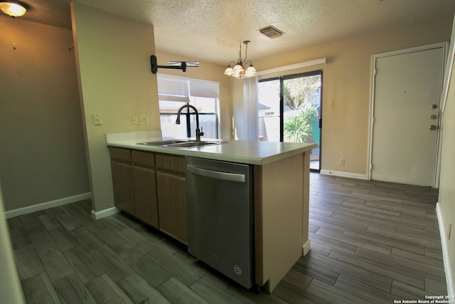 kitchen featuring dishwasher, dark wood-type flooring, a textured ceiling, and sink