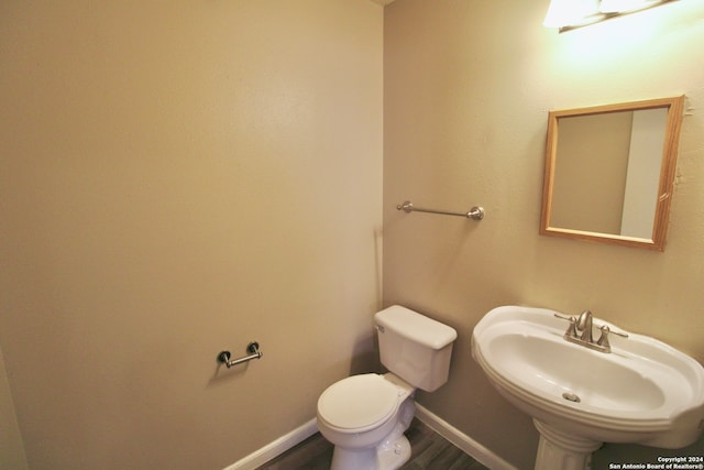 bathroom with hardwood / wood-style flooring, sink, and toilet