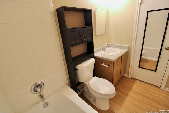 full bathroom with toilet, vanity, tiled shower / bath combo, and hardwood / wood-style flooring