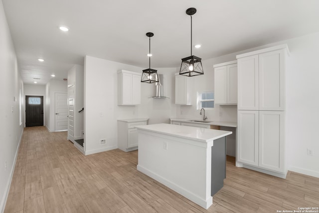 kitchen featuring white cabinets, plenty of natural light, a center island, and light hardwood / wood-style flooring