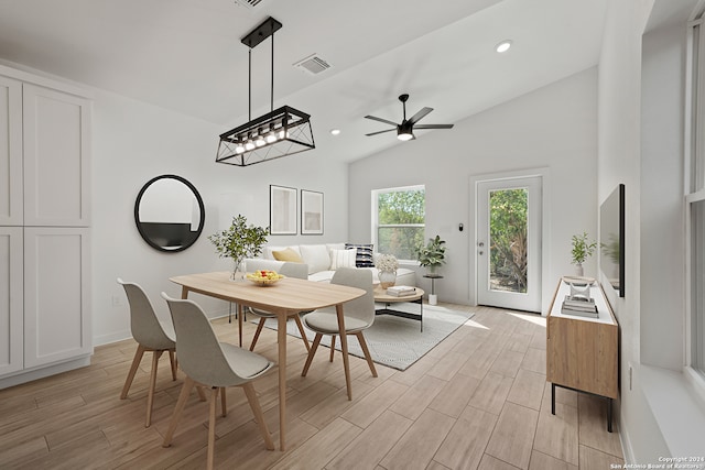 dining area with light wood-type flooring, vaulted ceiling, and ceiling fan