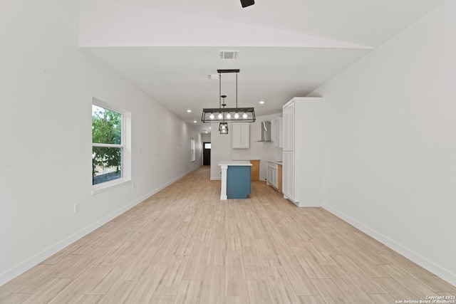 unfurnished living room with light hardwood / wood-style flooring and vaulted ceiling