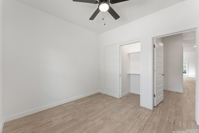 unfurnished bedroom featuring ceiling fan, a closet, and light wood-type flooring