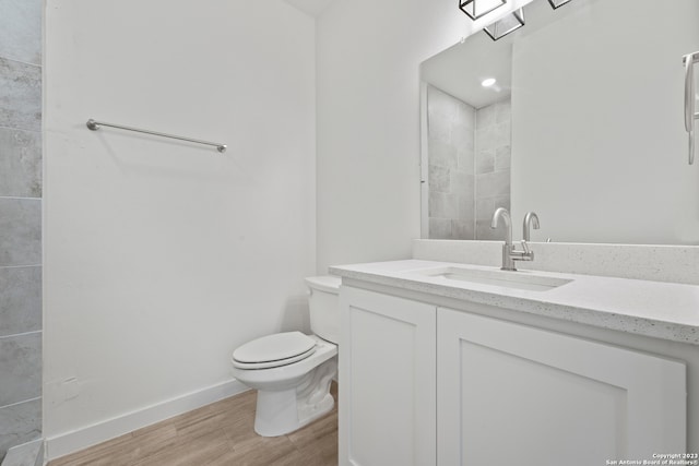 bathroom featuring vanity, hardwood / wood-style flooring, and toilet