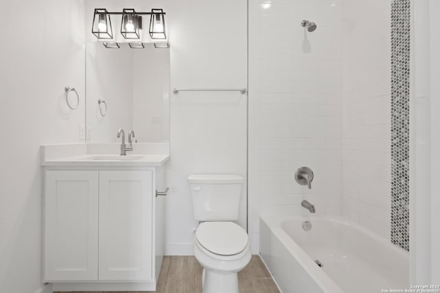 full bathroom featuring hardwood / wood-style flooring, vanity, toilet, and tiled shower / bath