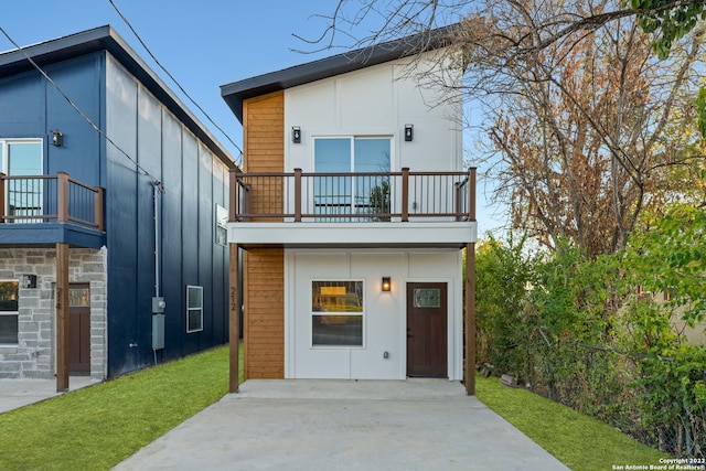 back of house with a yard and a balcony