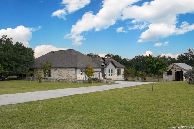 2407 Fm 1283, Pipe Creek, TX 78063 - french country inspired facade with a front yard, stone siding, and concrete driveway