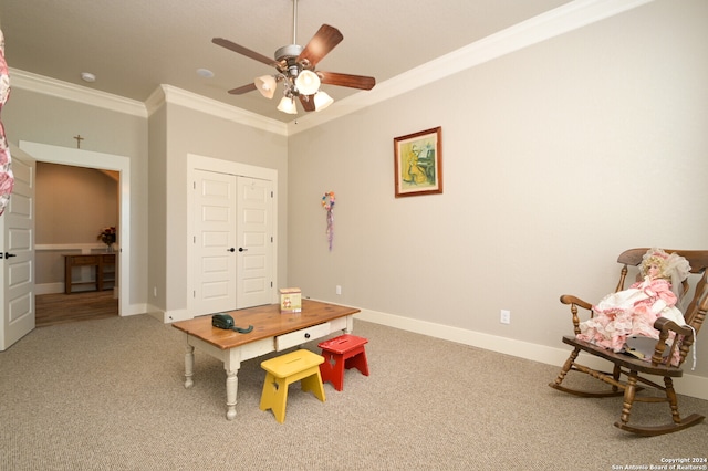 playroom with carpet floors, crown molding, and ceiling fan