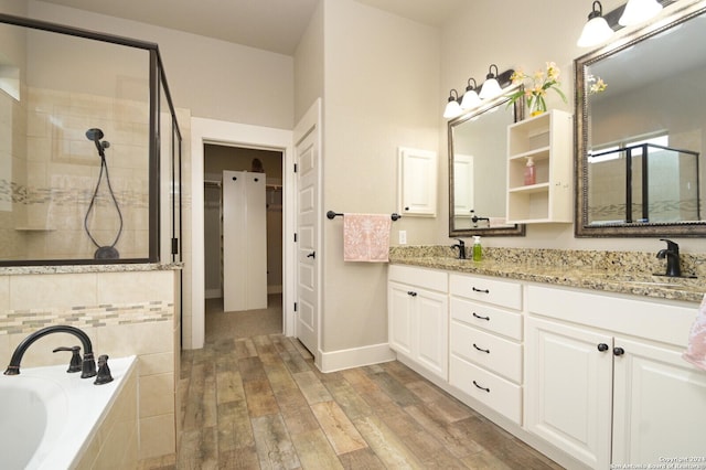 2407 Fm 1283, Pipe Creek, TX 78063 - bathroom with a tile shower, double vanity, a garden tub, wood finished floors, and baseboards