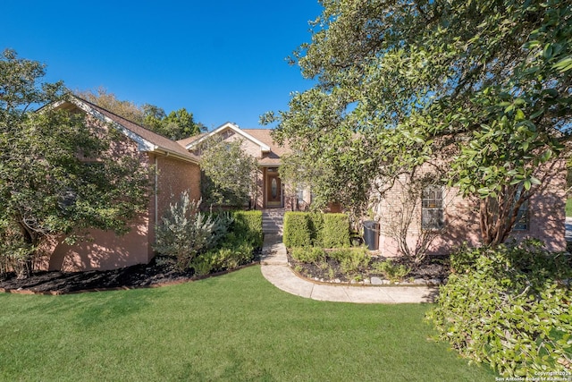 view of front of house with a front lawn and brick siding