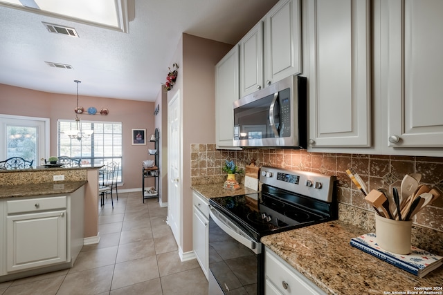 kitchen featuring an inviting chandelier, white cabinets, decorative backsplash, appliances with stainless steel finishes, and decorative light fixtures