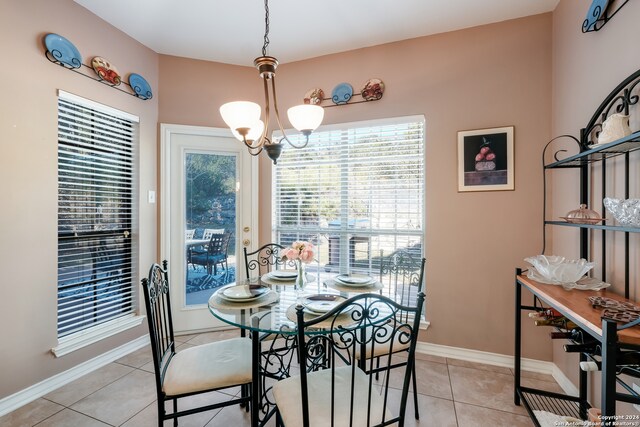 tiled dining room with a notable chandelier