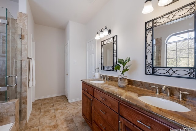 full bathroom with a shower stall, double vanity, tile patterned flooring, and baseboards