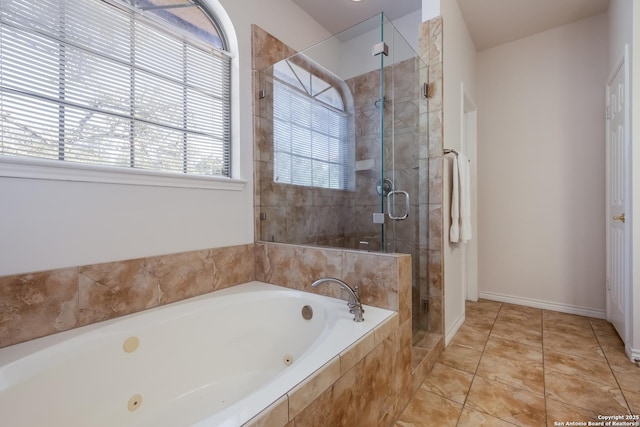 bathroom with a stall shower, a jetted tub, baseboards, and tile patterned flooring
