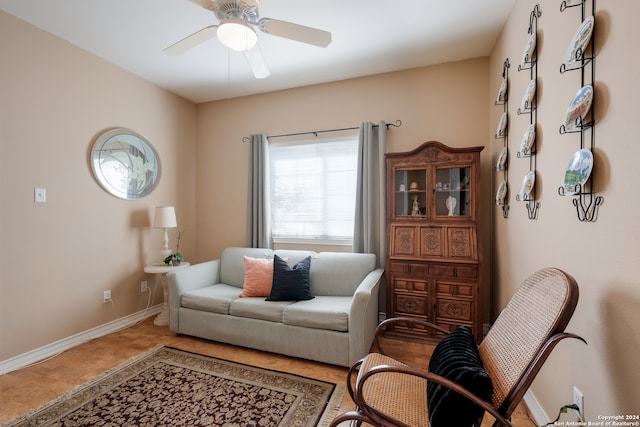 sitting room featuring ceiling fan and tile patterned flooring