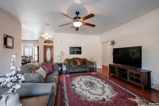 living room with ceiling fan and dark wood-type flooring