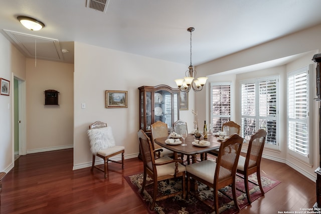 dining space featuring dark hardwood / wood-style flooring and a chandelier