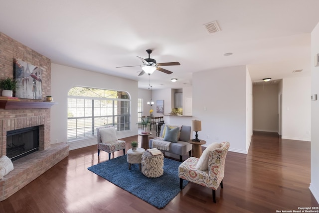 living area with wood finished floors, baseboards, a ceiling fan, and a brick fireplace