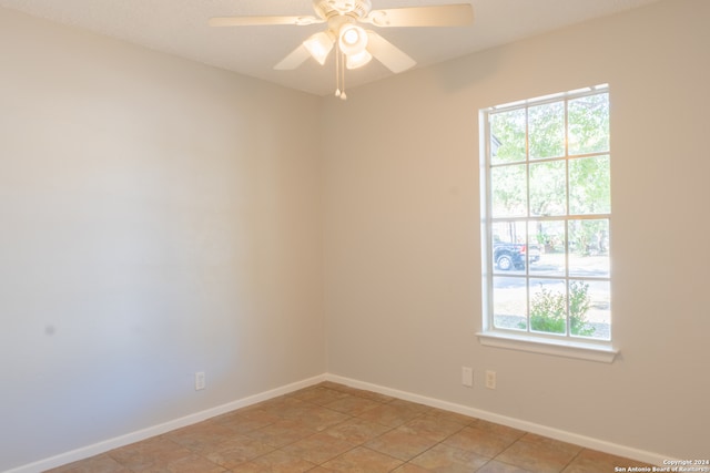 tiled spare room featuring ceiling fan