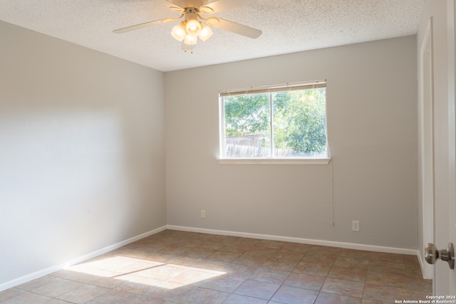 unfurnished room with ceiling fan, light tile patterned flooring, and a textured ceiling