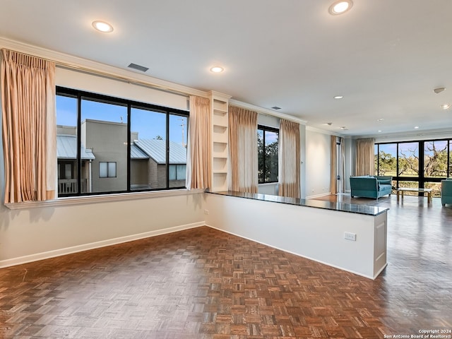 kitchen featuring dark parquet floors, a healthy amount of sunlight, and ornamental molding