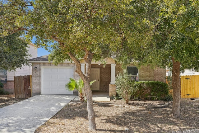 view of property hidden behind natural elements featuring a garage