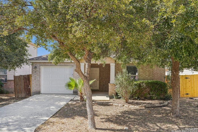 2115 Clear Ct, San Antonio, TX 78227 - view of property hidden behind natural elements with a garage, brick siding, fence, and driveway