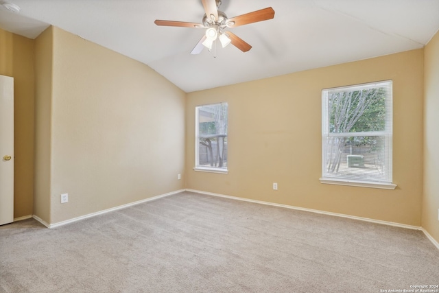 carpeted empty room with ceiling fan and vaulted ceiling