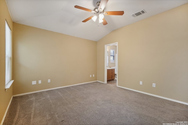 carpeted empty room featuring ceiling fan and vaulted ceiling