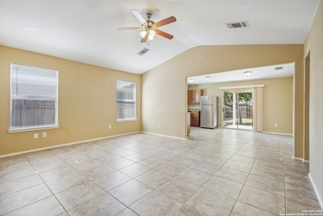 unfurnished room with ceiling fan, light tile patterned floors, and vaulted ceiling