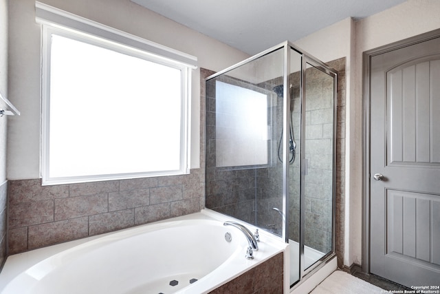 bathroom featuring separate shower and tub