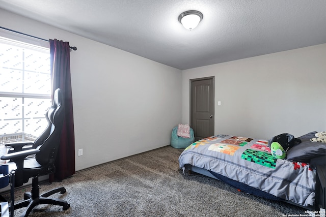 bedroom with carpet, a textured ceiling, and multiple windows