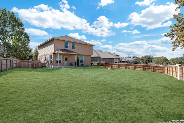 back of house with a lawn and a patio area