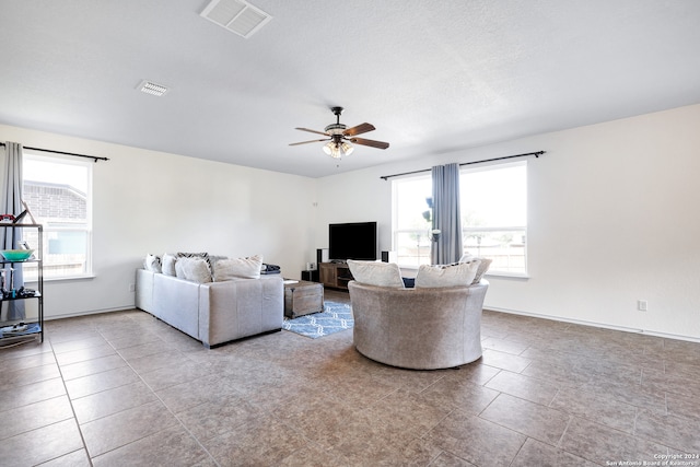 living room with light tile patterned floors, ceiling fan, and a healthy amount of sunlight