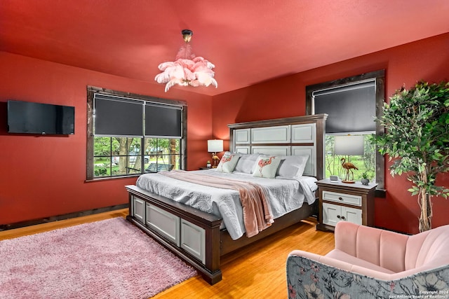 bedroom featuring light wood-type flooring and an inviting chandelier