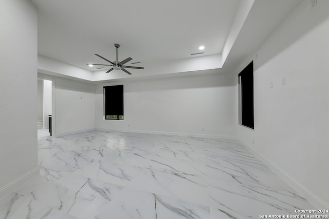 unfurnished room featuring a tray ceiling and ceiling fan