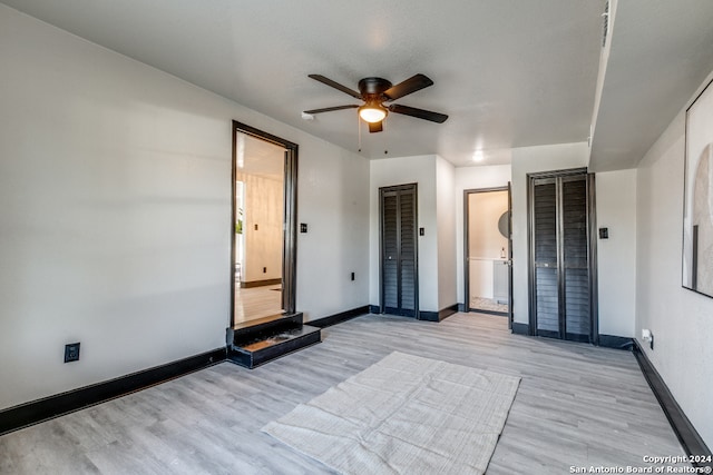 empty room with ceiling fan and light wood-type flooring