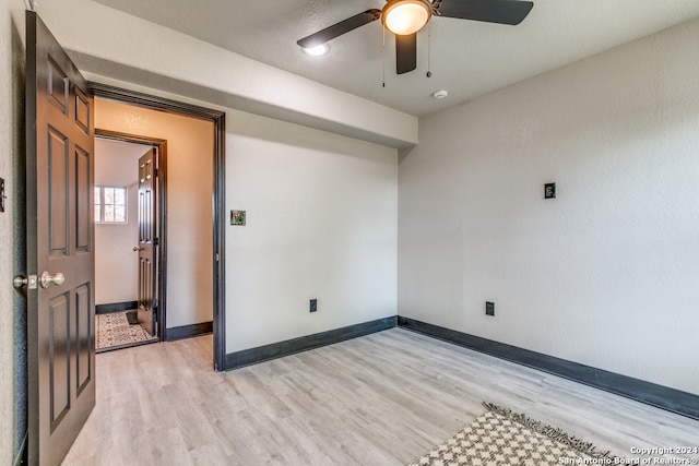 spare room with ceiling fan, a textured ceiling, and light hardwood / wood-style flooring