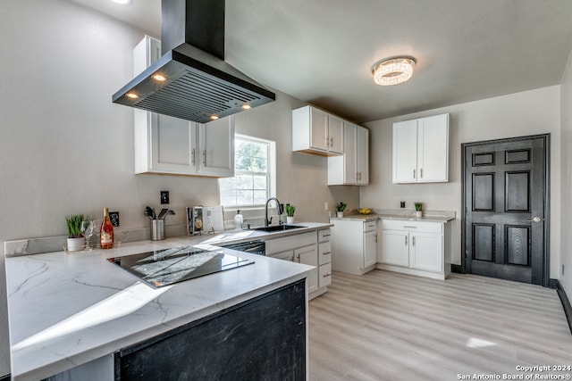 kitchen with white cabinetry, island range hood, sink, and light hardwood / wood-style flooring