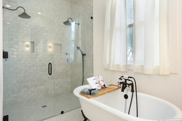 bathroom featuring shower with separate bathtub