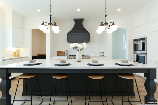 kitchen with custom range hood, backsplash, hanging light fixtures, and a large island