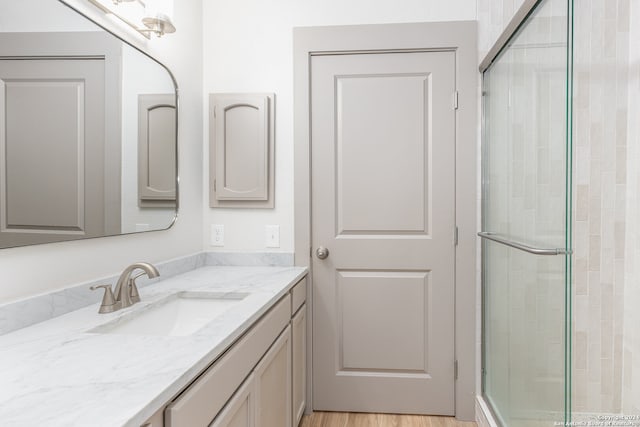 bathroom featuring vanity, a shower with shower door, and hardwood / wood-style flooring