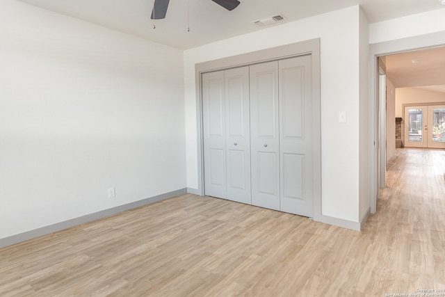 unfurnished bedroom with ceiling fan, light wood-type flooring, and a closet