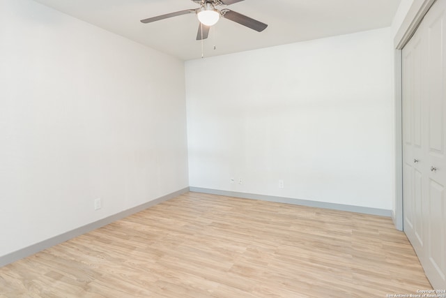 empty room with ceiling fan and light hardwood / wood-style floors