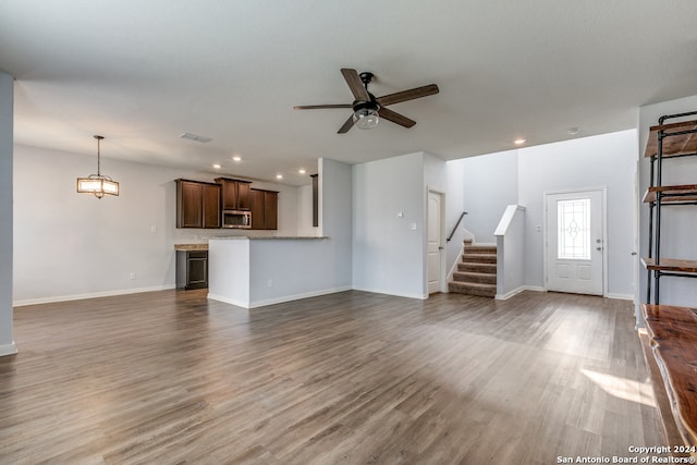 unfurnished living room with ceiling fan and hardwood / wood-style flooring