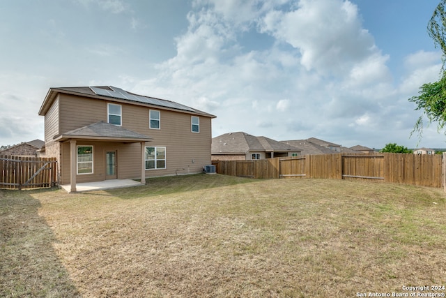 rear view of house featuring solar panels, a patio, a lawn, and central air condition unit