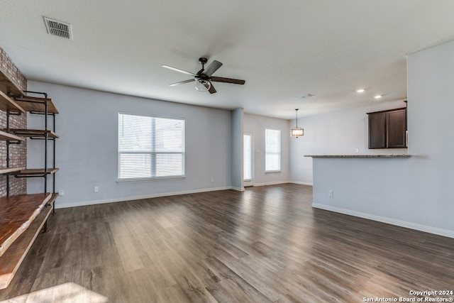 unfurnished living room featuring ceiling fan and dark hardwood / wood-style flooring