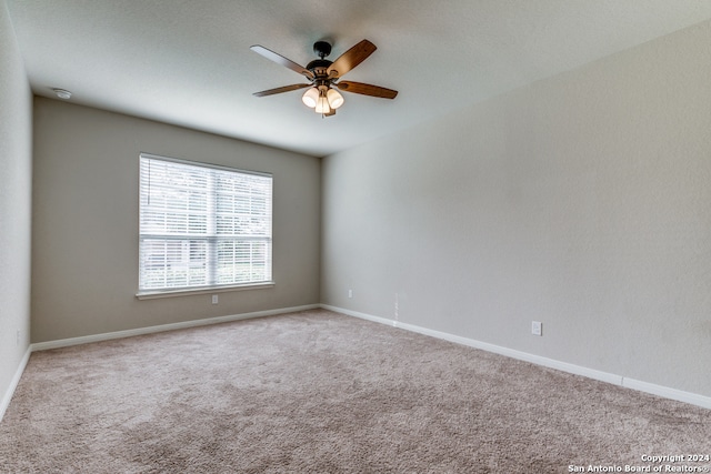 carpeted spare room with ceiling fan