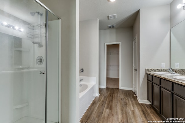 bathroom with hardwood / wood-style floors, vanity, shower with separate bathtub, and a textured ceiling